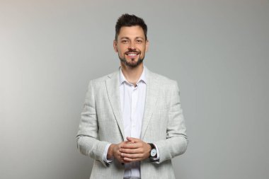 Bej arka planda hafif takım elbiseli mutlu öğretmen