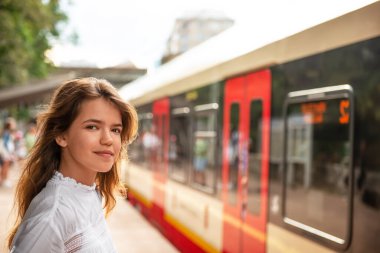 Tren durağındaki genç kız, mesaj atmak için yer var.