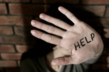 Aile içi şiddet kavramı. Yüzünü gizleyen kadın, elinle yazıya odaklan Yardım et