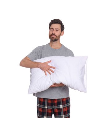 Beyaz arka planda yumuşak yastıklı uykulu yakışıklı adam.