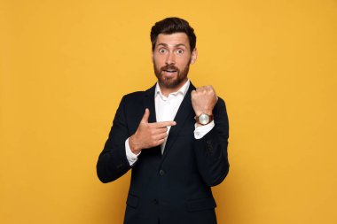 Duygusal adam turuncu arka planda nöbet tutuyor. Geç kalma kavramı