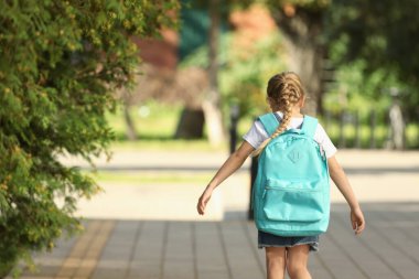 Sırt çantalı küçük bir kız okula gidiyor. Metin için boşluk