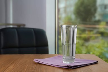 Glass of pure water on wooden table indoors, space for text