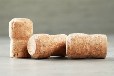 Şarap şişelerinin tıpaları açık gri masada, yakın plan.