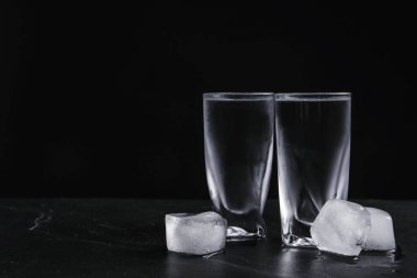Siyah arka planda buzlu shot bardakta votka. Metin için boşluk