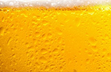 Glass of tasty cold beer with foam and condensation drops on white background, closeup clipart