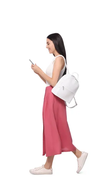 Νεαρή Γυναίκα Που Χρησιμοποιεί Smartphone Ενώ Περπατά Λευκό Φόντο — Φωτογραφία Αρχείου