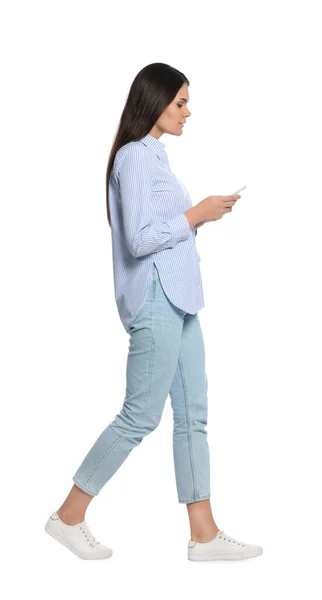 Mujer Joven Con Smartphone Caminando Sobre Fondo Blanco —  Fotos de Stock