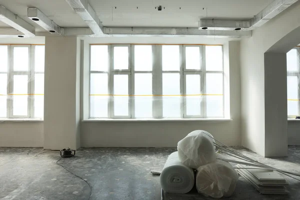 Polyethylene foam rolls on floor near windows in room