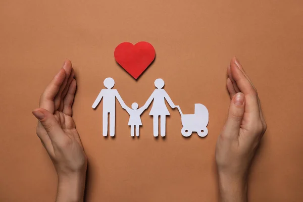 Donna Che Protegge Figure Famiglia Carta Cuore Rosso Sfondo Marrone — Foto Stock