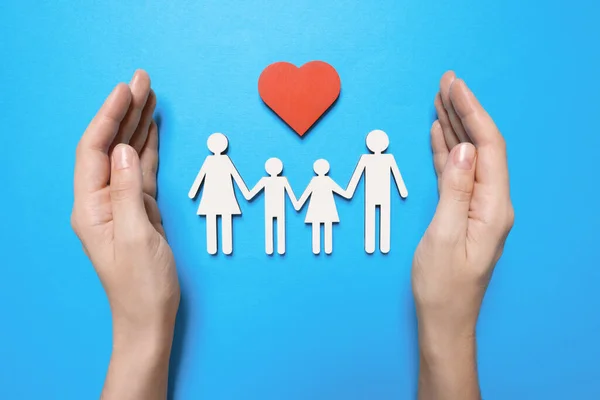 Vrouw Beschermt Familieleden Lichtblauwe Achtergrond Bovenaanzicht Verzekeringsconcept — Stockfoto