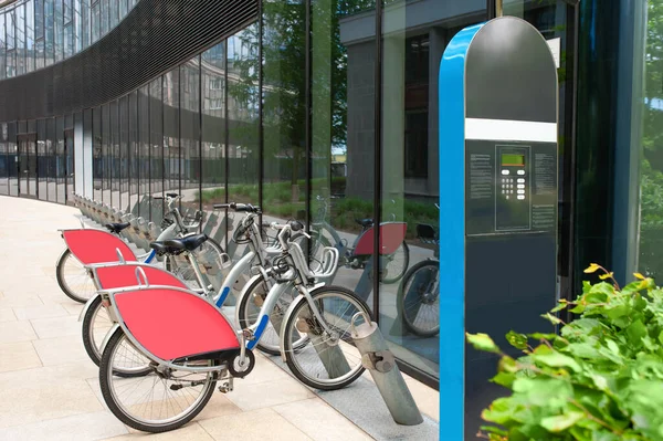 Payment terminal near parking lot with many bicycles outdoors