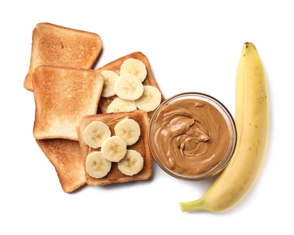 Tasty toasts with nut butter and banana on white background, top view