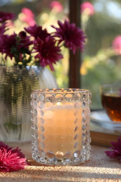 Brennende Duftkerze Glashalter Und Chrysanthemenblüten Auf Beige Strukturiertem Tisch Herbstzeit — Stockfoto