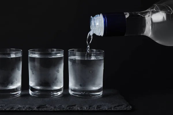 Verter Vodka Botella Cristal Sobre Mesa Negra —  Fotos de Stock