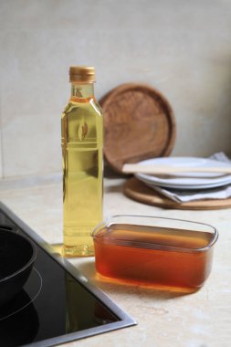 Mutfak tezgahındaki ocağın yanında yeni ve kullanılmış yemek yağı.