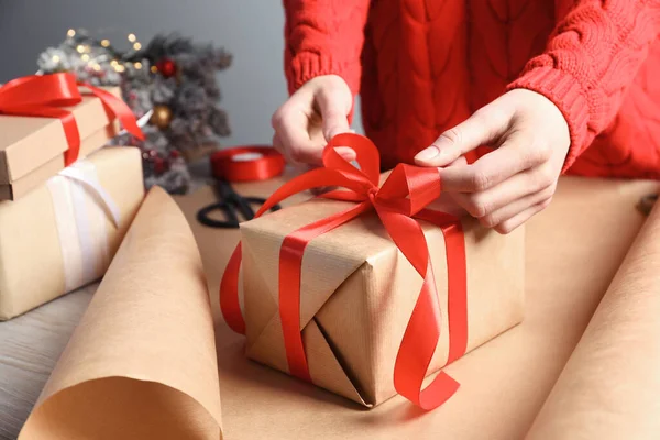 Рождественский Подарок Женщина Завязывает Ленту Бантом Подарочной Коробке Столом Крупным — стоковое фото