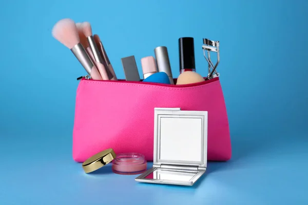 Stilvoller Taschenspiegel Und Kosmetiktasche Mit Make Produkten Auf Hellblauem Hintergrund — Stockfoto
