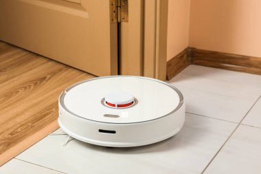 Beyaz zeminde modern robotik elektrikli süpürge.