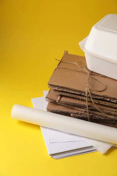 Heap of waste paper on yellow background