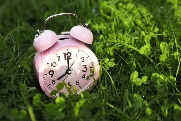 緑の草の上の小さな目覚まし時計 テキストのためのスペース — ストック写真