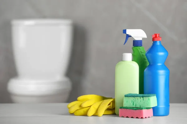 Cleaning supplies on table in bathroom, space for text
