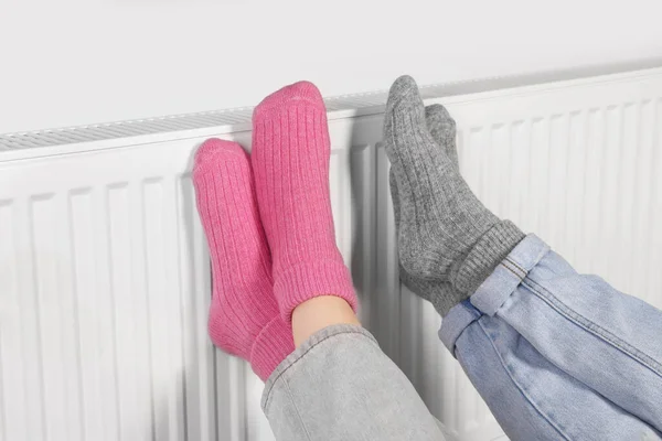 People Warming Feet Heating Radiator Closeup — Stock Photo, Image