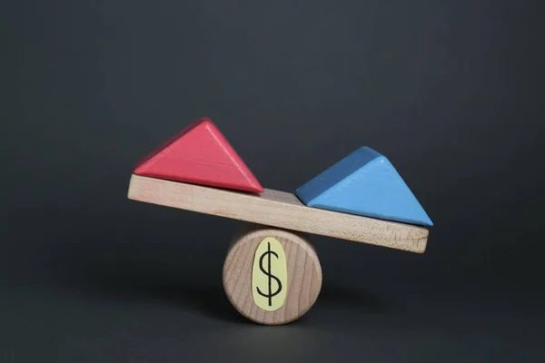 Gender pay gap. Wooden triangles as male and female symbols on miniature seesaw against black background
