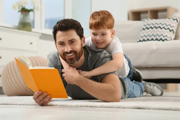 Πατέρας Διαβάζει Βιβλίο Παιδί Του Στο Πάτωμα Στο Σπίτι — Φωτογραφία Αρχείου