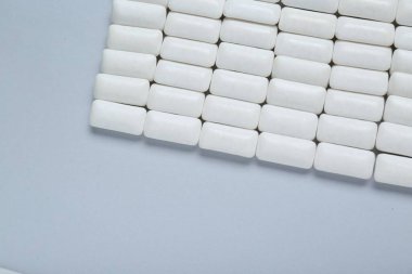 Açık gri arka planda dişeti çiğneyen lezzetli, düz bir zemin. Metin için boşluk