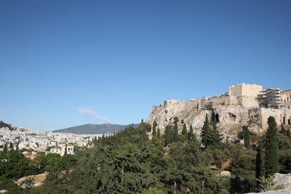 Güneşli bir günde şehir manzarası, güzel evler ve akropolis.