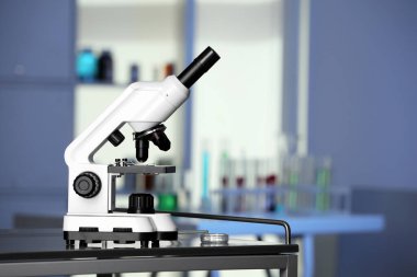 Modern medical microscope on metal table in laboratory, space for text
