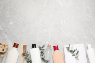 Şampuan şişeleri, ahşap tarak, gerekli yağ, havlu, lif ve yapraklar beyaz desenli masa, düz yatak. Metin için boşluk