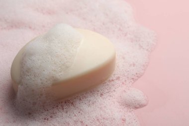 Pembe arka planda tüylü köpüklü sabun, yakın plan. Metin için boşluk
