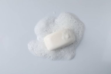 Beyaz arka planda kabarık köpüklü sabun, üst görünüm