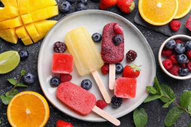 Siyah desenli masa üzerinde farklı lezzetli buz parçaları tabağı, düz. Meyveli dondurma.