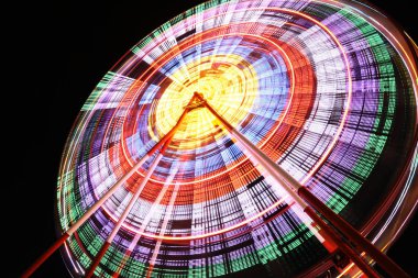 Beautiful glowing Ferris wheel against dark sky, low angle view