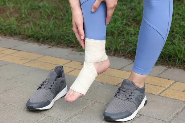 Woman with foot wrapped in medical bandage on outdoors, closeup