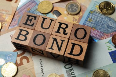 Sözcük Eurobond 'u ve euro banknotları üzerinde paralar olan tahta küpler