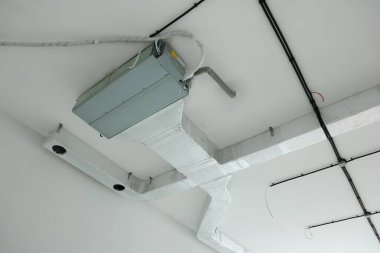 Tavanda borular ve kablolar olan havalandırma sistemi