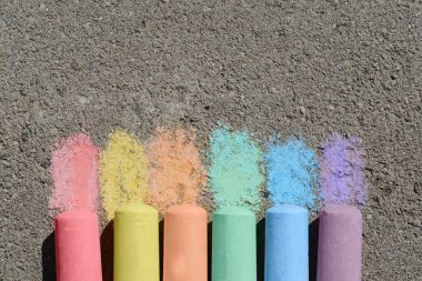 Dışarıdaki asfaltta renkli tebeşir çubukları, düz yerde. Metin için boşluk