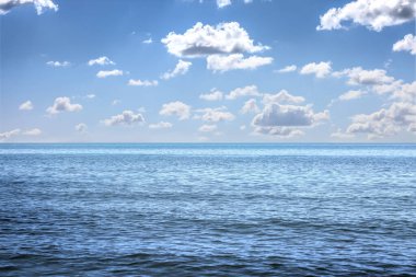 Güzel deniz manzarası ve güneşli bir günde beyaz bulutlu mavi gökyüzü.