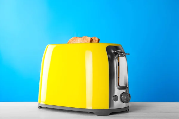 现代烤面包机 在白木桌上放有烤面包片 — 图库照片
