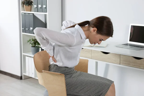 オフィスに座っている間に腰痛に苦しむ女性 大腸炎の症状 — ストック写真