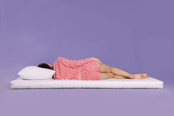 Mujer Joven Durmiendo Colchón Suave Sobre Fondo Púrpura Claro Vista —  Fotos de Stock