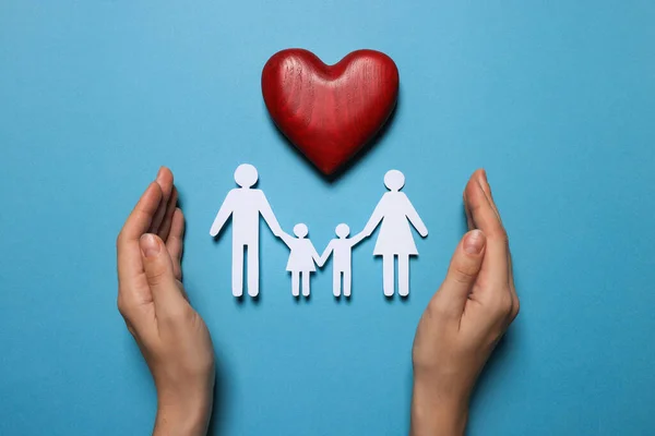 Mulher Que Protege Figuras Família Papel Coração Madeira Vermelho Fundo — Fotografia de Stock