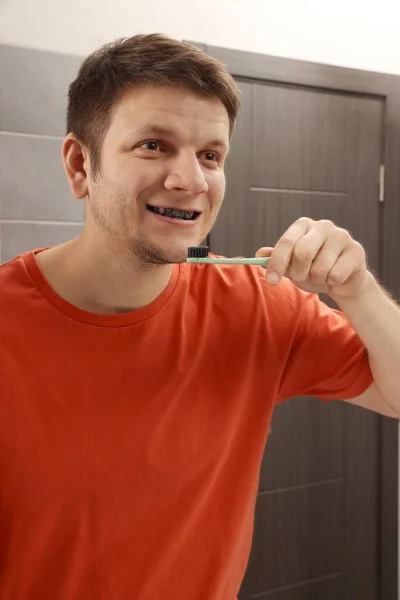 Mies Harjaamalla Hampaat Hiili Hammastahna Kylpyhuoneessa — kuvapankkivalokuva