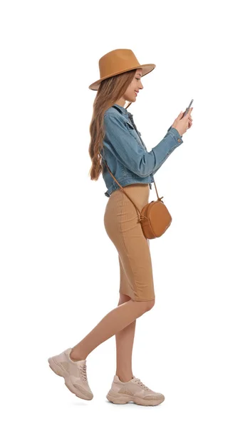 Νεαρή Γυναίκα Casual Outfit Χρησιμοποιώντας Smartphone Ενώ Περπατάτε Λευκό Φόντο — Φωτογραφία Αρχείου