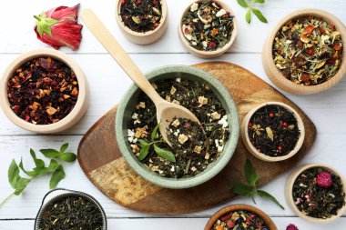 Beyaz ahşap masa üzerinde birçok farklı bitkisel çay, düz yatıyordu.