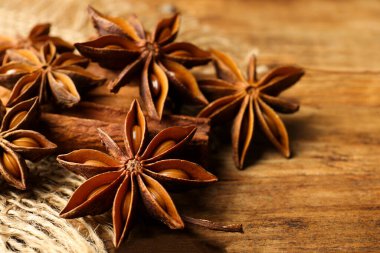 Aromatik anason yıldızları ve tarçın çubukları ahşap masada, yakın plan.